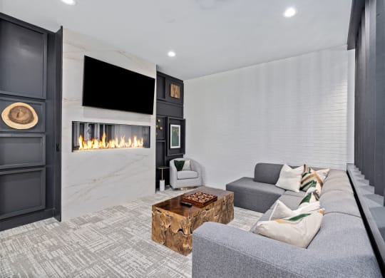 a living room with a gray couch and a fireplace