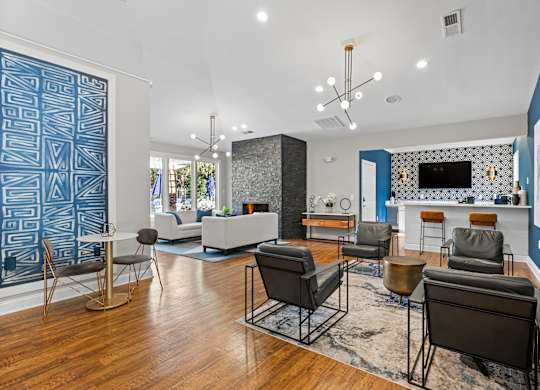 A living room with a blue accent wall and a patterned blue wallpaper.