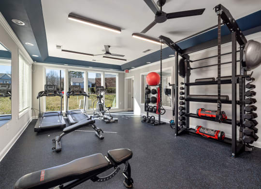 addison point interior resident gym with weights and equipment and windows