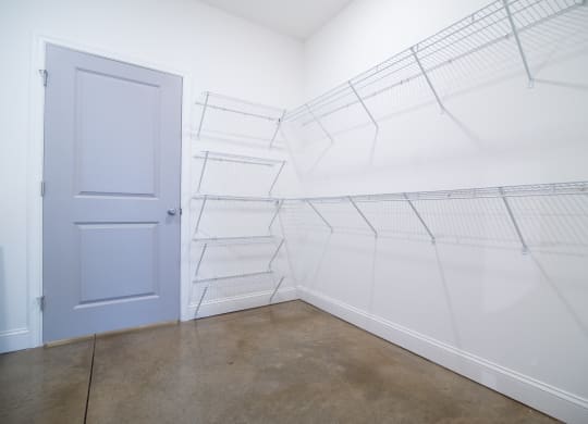 a room with white walls and a blue door in it