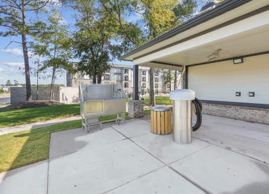 the patio has a grill and a trash can on it