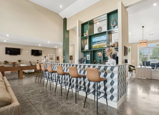 the gathering room has a bar with stools and a community kitchen