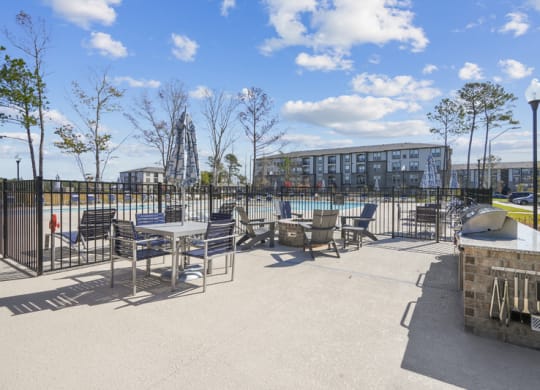 a patio with tables and chairs next to a pool