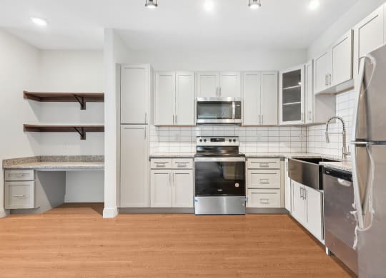 a kitchen with white cabinets and stainless steel appliances