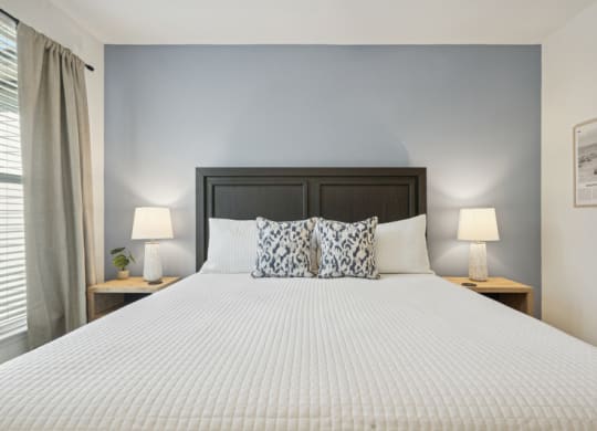 a bedroom with a large bed and two night stands with lamps