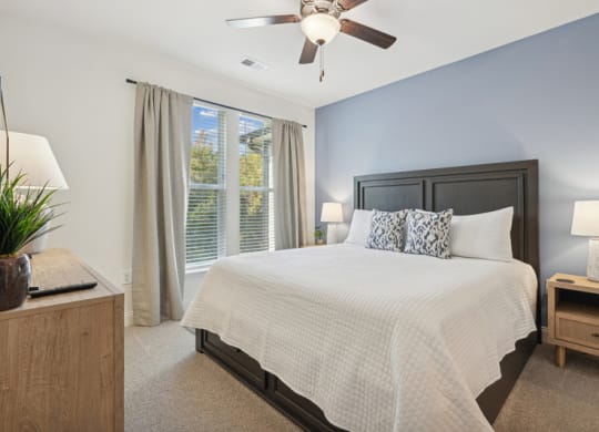 a bedroom with a large bed and a ceiling fan