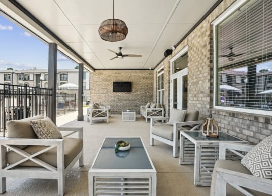 an outdoor patio with chairs and tables and a television