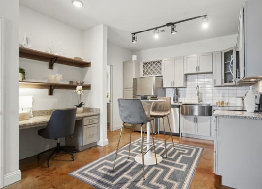 a kitchen and living room with a bar and a table with chairs