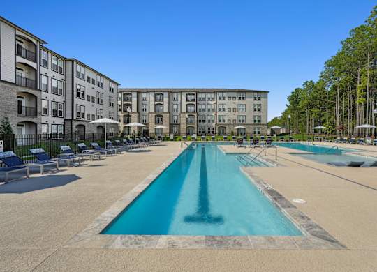 A large swimming pool in front of apartment buildings.