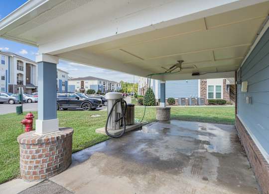 A red fire hydrant is on the left side of a concrete area under a covered walkway.