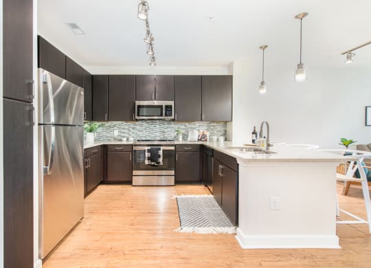 a large kitchen with stainless steel appliances and a white counter top