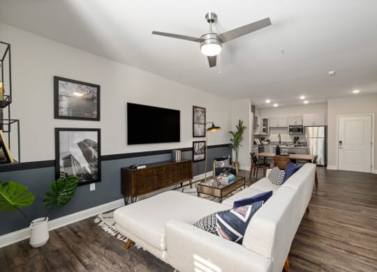 a living room with a white couch and a ceiling fan