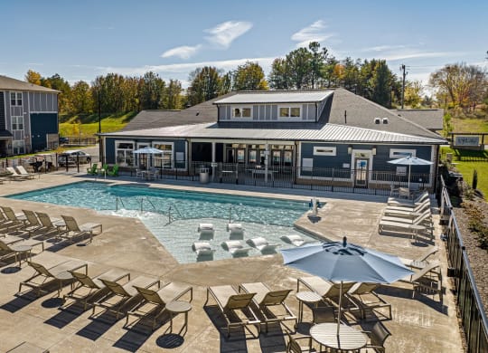 the resort style pool with lounge chairs and umbrellas