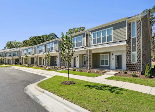 A row of modern houses with a clear blue sky above them.