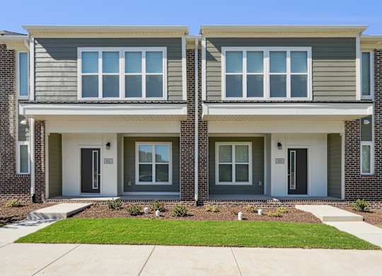 A modern two-story house with a grey and white exterior.