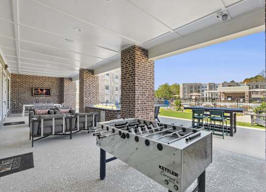 A Kettler outdoor grill is in the foreground of a patio area.