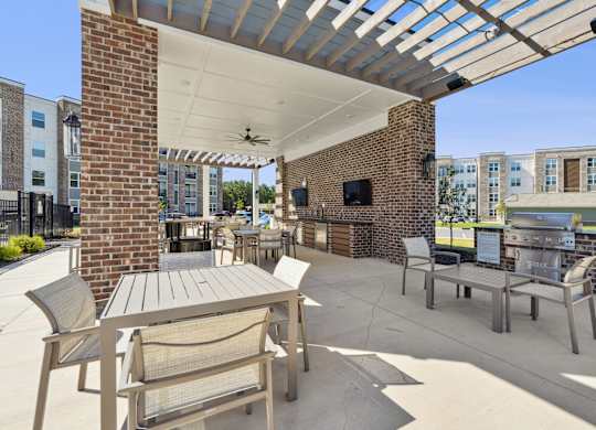 A patio with a table and chairs under a roof.