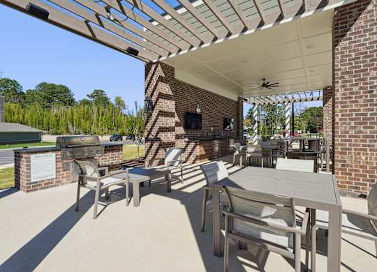 A patio with a table and chairs under a roof.
