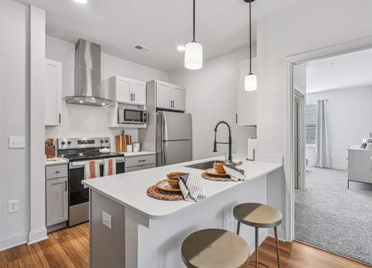 A modern kitchen with a white island and stainless steel appliances.