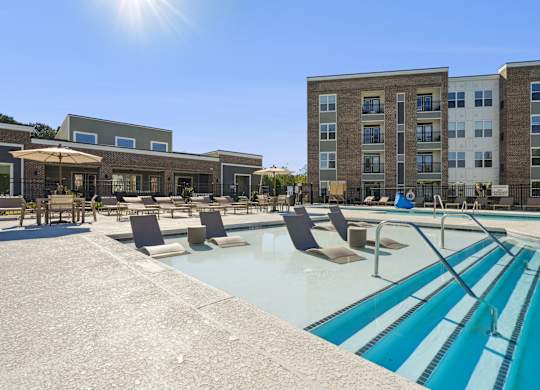 A sunny day at the pool with chairs and umbrellas.
