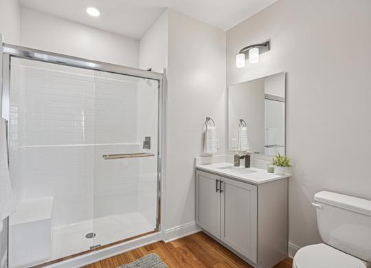 A white bathroom with a walk-in shower, toilet, and sink.