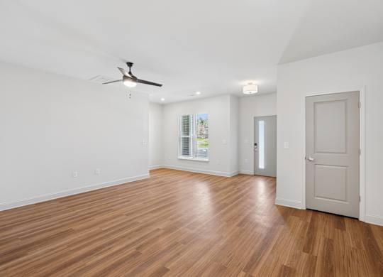 A room with wooden floors and a ceiling fan.
