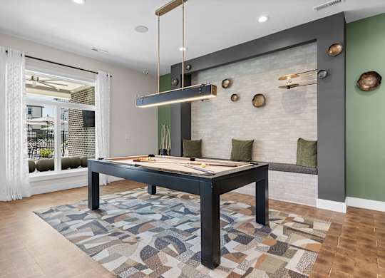 A room with a pool table and a green wall.