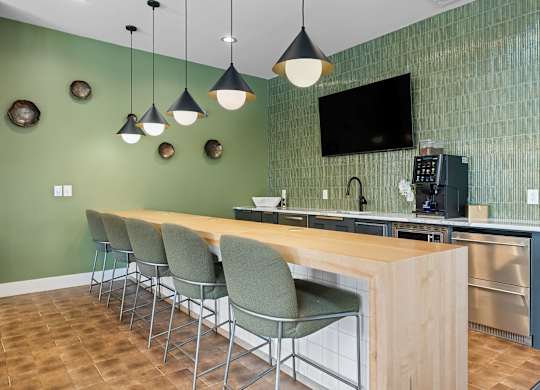 A kitchen with green walls and a wooden island.