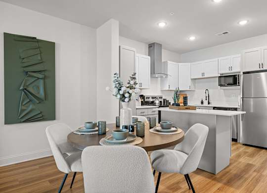 A modern kitchen with a dining table set for two.