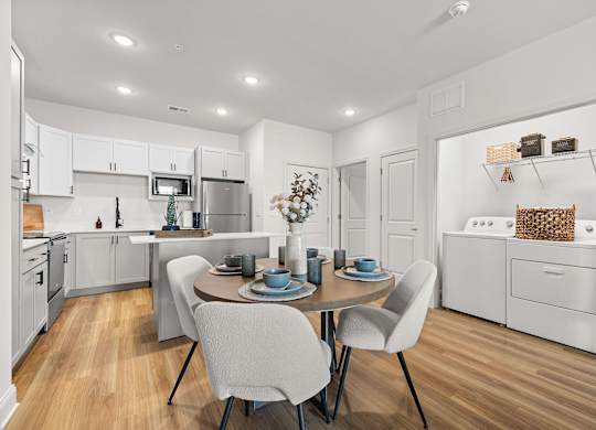A modern kitchen with a dining table set for two.
