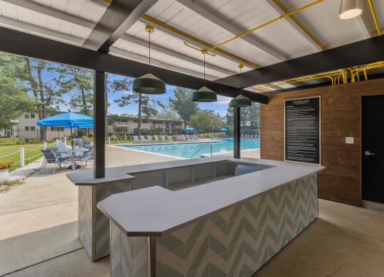 a poolside bar in the clubhouse of a resort with a swimming pool
