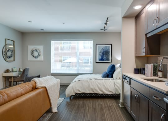 a bedroom with a bed and a kitchen with a sink