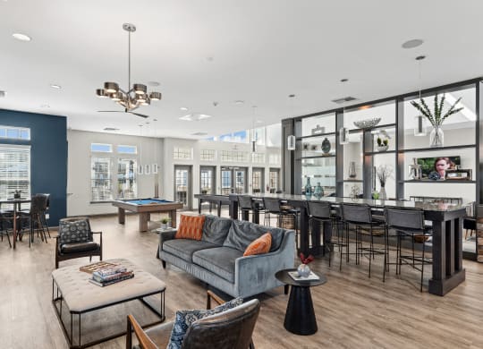 a living room with couches chairs and tables and a bar