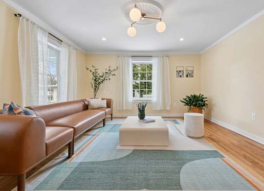 A living room with a brown leather couch and a white coffee table.