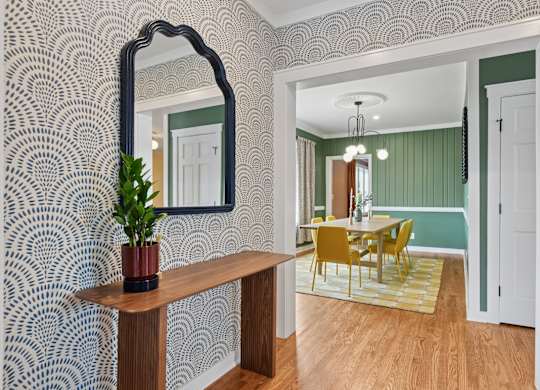 A room with a mirror, a table, and chairs.