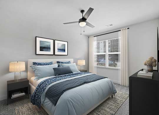 A bedroom with a bed, two lamps, a ceiling fan, and two pictures on the wall.