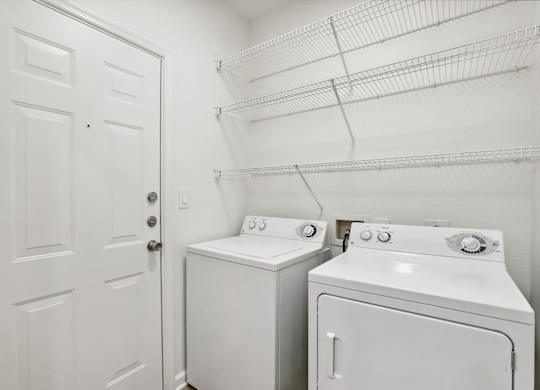 A white laundry room with a washer and dryer.