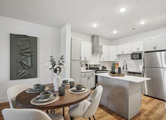 A modern kitchen with a dining table set for two.