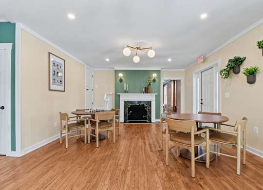 A dining room with a fireplace and wooden floors.
