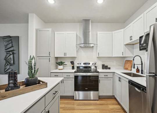 A modern kitchen with stainless steel appliances and white cabinets.