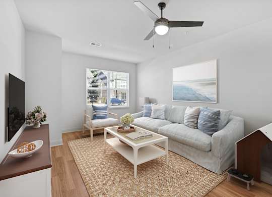 A living room with a grey couch, a white coffee table, and a painting on the wall.