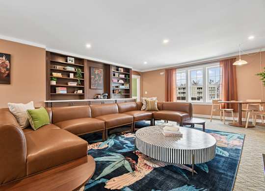 A living room with brown leather furniture and a round coffee table.