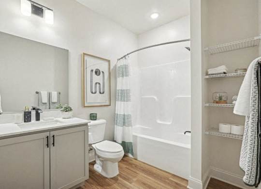 A bathroom with a toilet, sink, and shower.