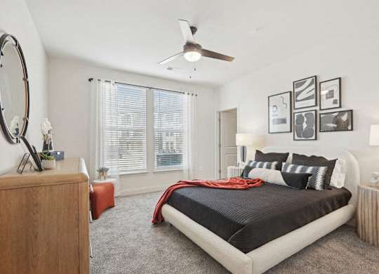 A bedroom with a large bed and a wooden dresser.