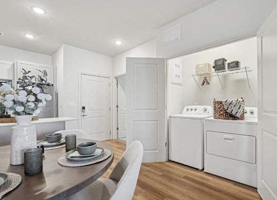 A modern kitchen with a dining table set for two.