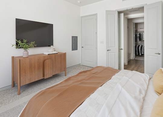 A bedroom with a large bed and a tv on a cabinet.