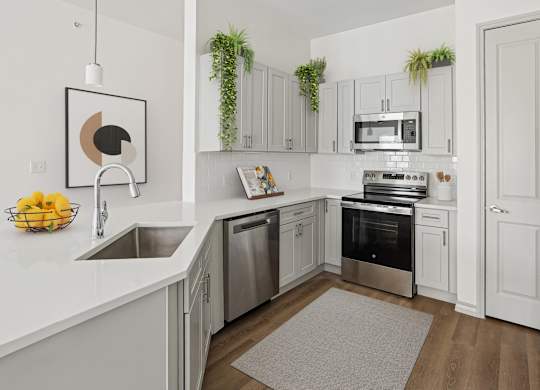 A modern kitchen with stainless steel appliances and white cabinets.