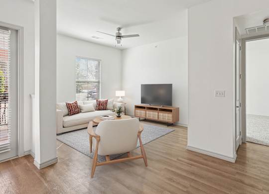 A living room with a white chair and a wooden floor.