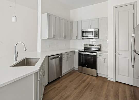 A kitchen with white cabinets and stainless steel appliances.