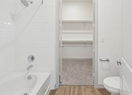 A white bathroom with a walk-in shower and a toilet.
